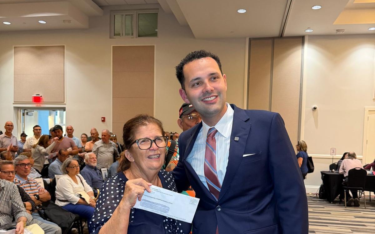 Mayor Calvo presenting tax relief to a Hialeah senior